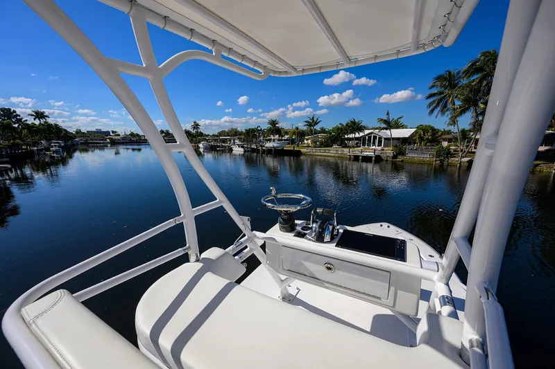 Slide: The Image of 2021 Invincible 39 Open Fisherman boat on a serene waterway with palm trees. - 15