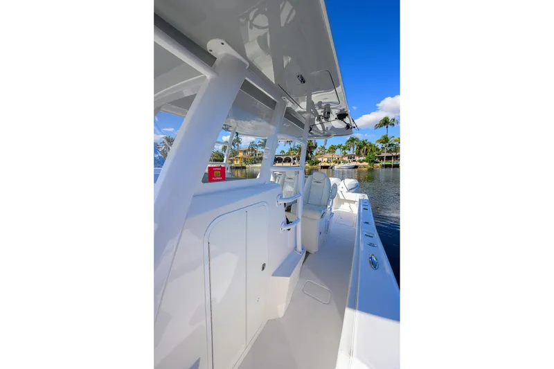 Slide: The Image of 2021 Invincible 39 Open Fisherman boat on calm water, clear sky, palm trees in background. - 24