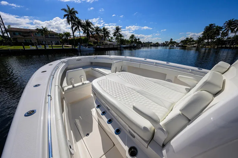 Slide: The Image of 2021 Invincible 39 Open Fisherman boat with luxurious seating, docked by palm trees. - 29