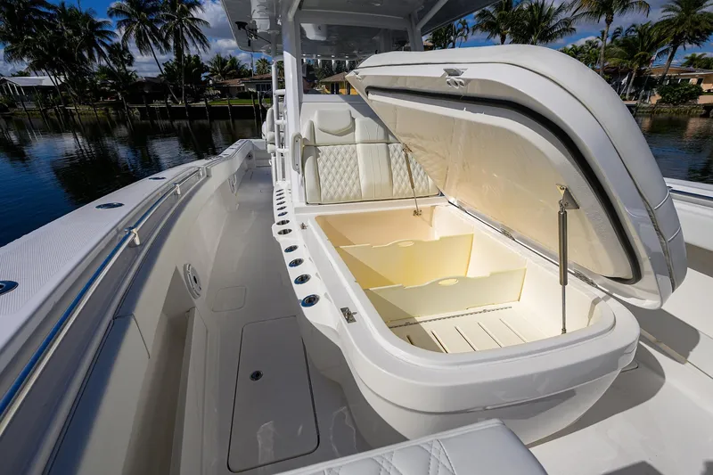 Slide: The Image of 2021 Invincible 39 Open Fisherman boat with open storage compartment, docked by palm trees. - 42