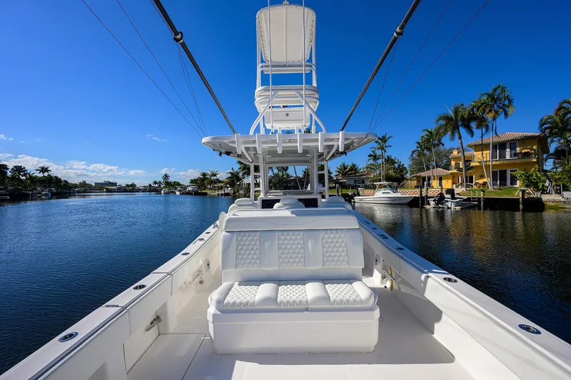Slide: The Image of 2021 Invincible 39 Open Fisherman boat on a scenic waterfront with palm trees. - 54