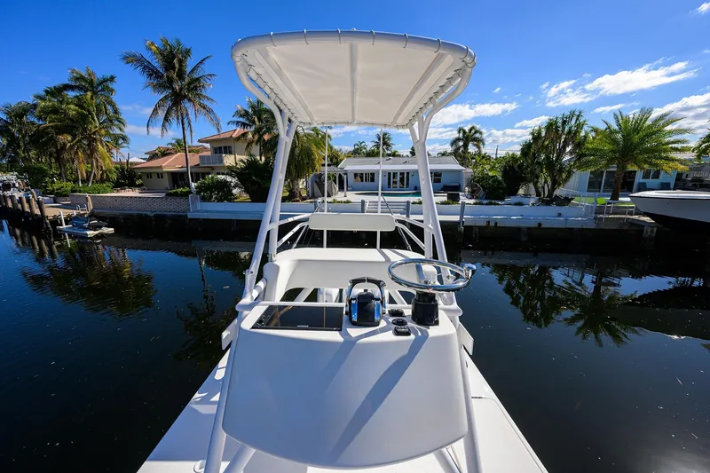 Slide: The Image of 2021 Invincible 39 Open Fisherman boat docked by palm trees and waterfront homes. - 79