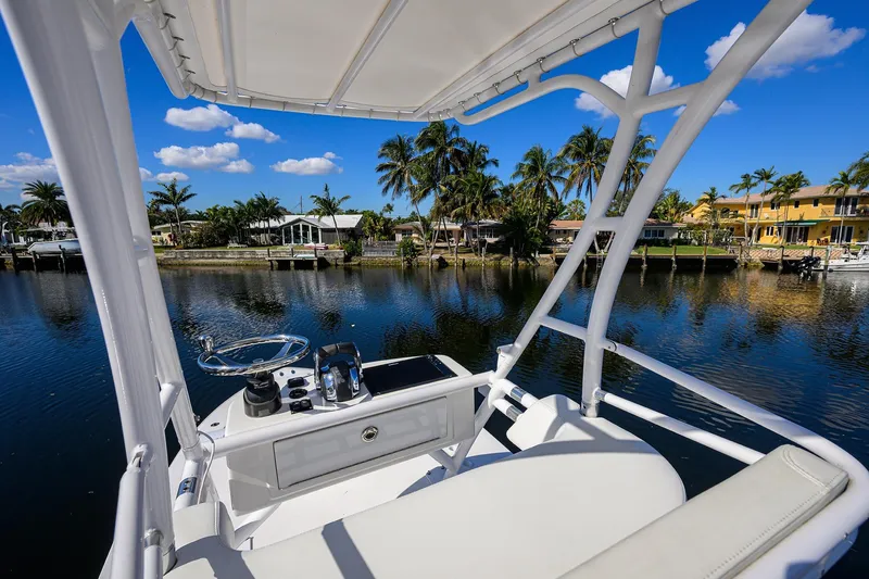 Slide: The Image of 2021 Invincible 39 Open Fisherman boat on a scenic waterfront with palm trees. - 84