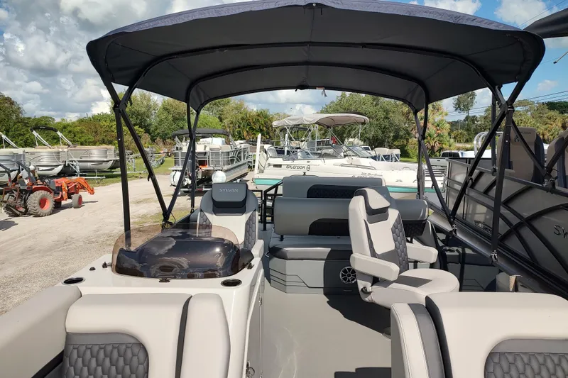Slide: The Image of 2026 Sylvan L3 DLZ pontoon boat with luxurious seating and canopy in a marina setting. - 11