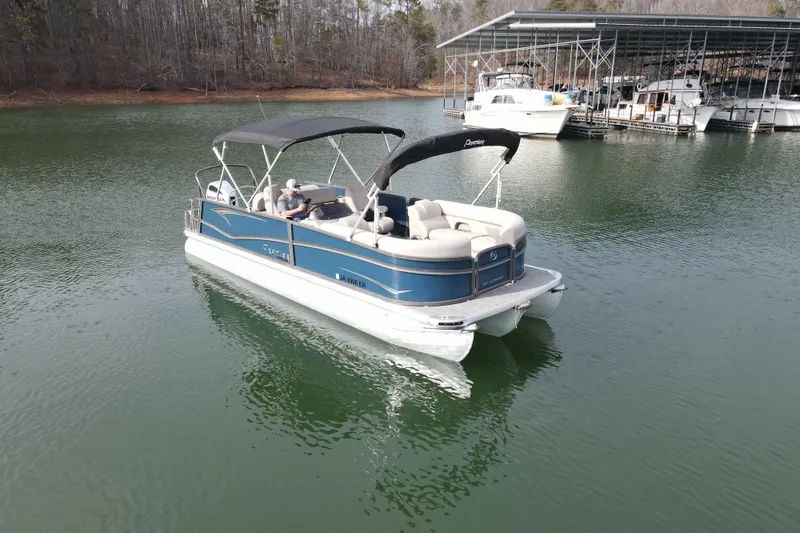 The Image of 2021 Premier 230 Sunsation RL PTX pontoon boat on a calm lake. - 1