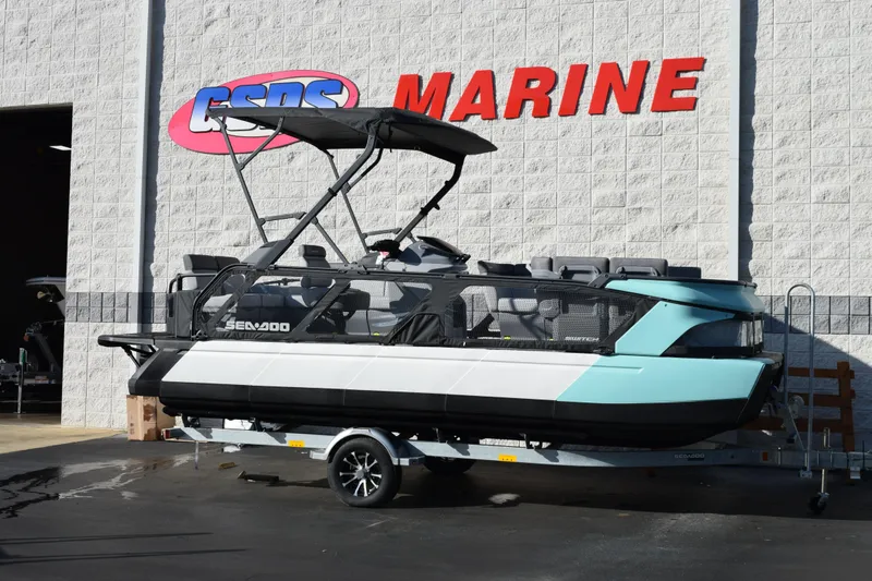 The Image of 2026 Sea-Doo Switch Cruise 21 pontoon boat on trailer outside marine dealership. - 1