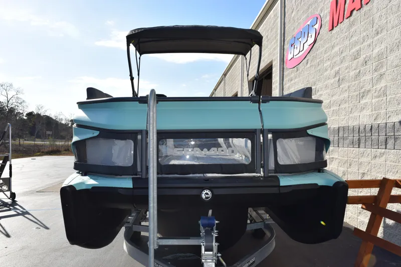 Slide: The Image of 2026 Sea-Doo Switch Cruise 21 pontoon boat, rear view, parked outside dealership. - 3