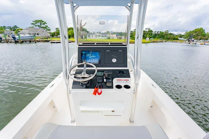 Slide: The Image of Manufacturer Provided Image: 2025 Bay Rider 219 Bay boat console with steering wheel on calm water. - 13
