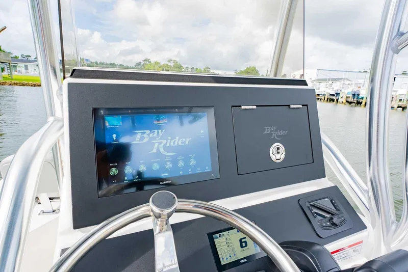 Slide: The Image of 2026 Bay Rider 219 Bay boat dashboard with Garmin display and steering wheel. - 15