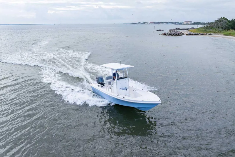 Slide: The Image of 2026 Bay Rider 219 Bay boat cruising on open water near shoreline. - 2
