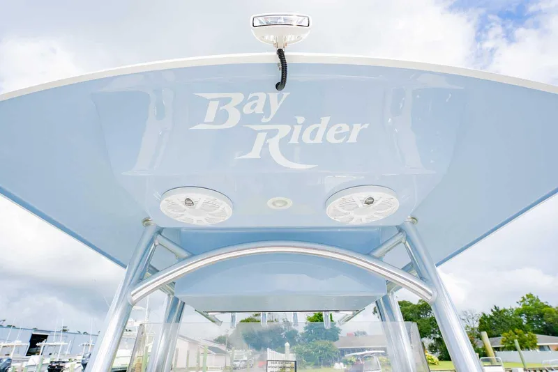 Slide: The Image of 2026 Bay Rider 219 Bay boat with T-top and speakers, under a cloudy sky. - 21