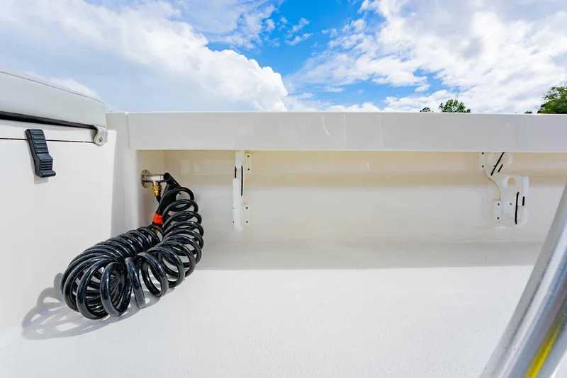 Slide: The Image of 2026 Bay Rider 219 Bay boat deck with coiled hose under blue sky. - 30