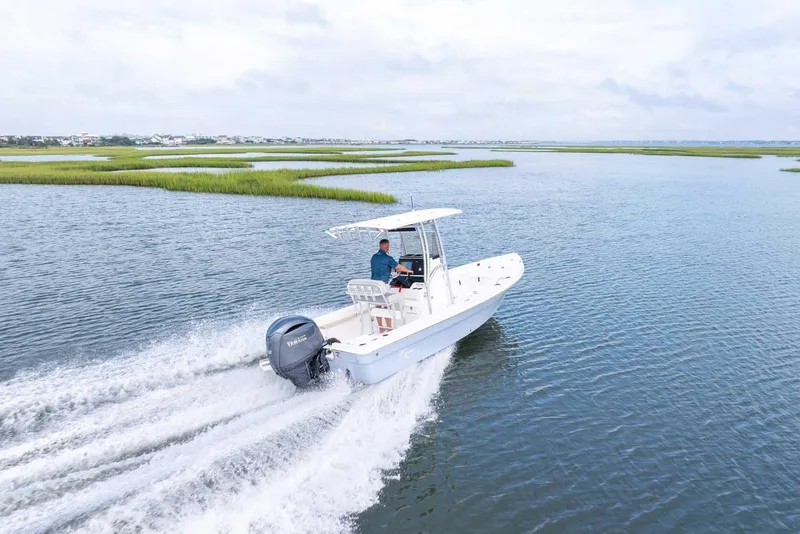 Slide: The Image of 2026 Bay Rider 219 Bay boat cruising on open water, scenic marshland background. - 4