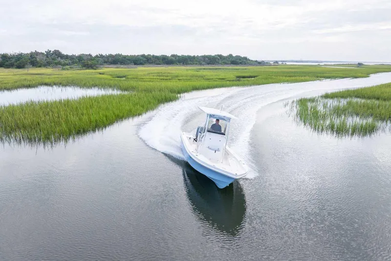 Slide: The Image of 2026 Bay Rider 219 Bay boat cruising through scenic marshland waterways. - 5