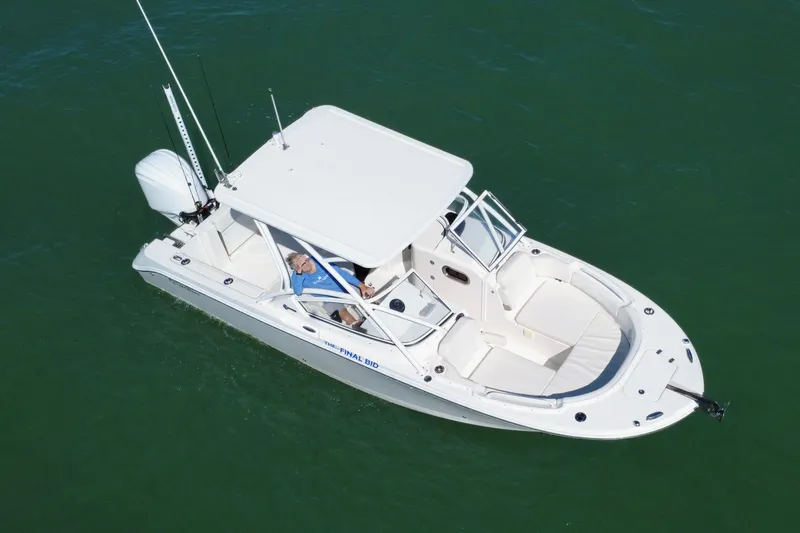 Slide: The Image of 2023 Edgewater 248CX Crossover boat on calm green water, showcasing sleek design. - 30