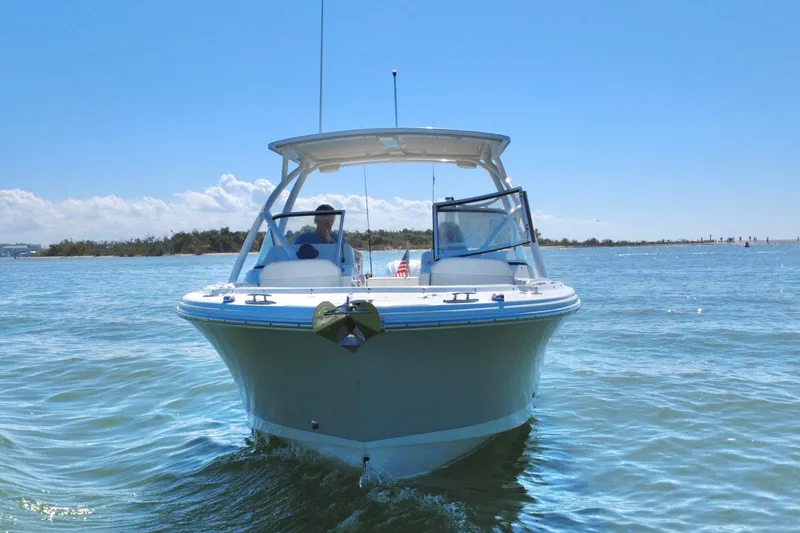 Slide: The Image of 2023 Edgewater 248CX Crossover boat cruising on calm blue waters. - 40