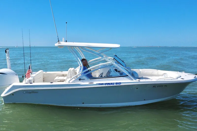 Slide: The Image of 2023 Edgewater 248CX Crossover boat on calm water under a clear blue sky. - 42