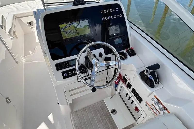 Slide: The Image of 2023 Edgewater 248CX Crossover boat cruising on calm blue waters. - 5