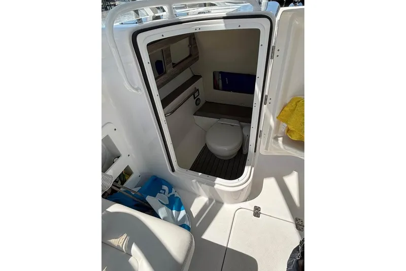 Slide: The Image of 2023 Edgewater 248CX Crossover boat interior with white seating and open windshield. - 8