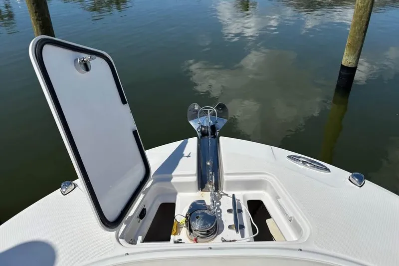 Slide: The Image of 2023 Edgewater 248CX Crossover boat in a serene marina with palm trees and waterfront homes. - 9