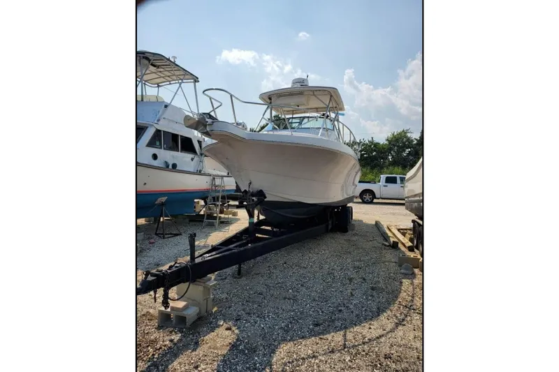 The Image of 1996 Pro-Line 2950 Walkaround boat on trailer in outdoor storage area. - 0