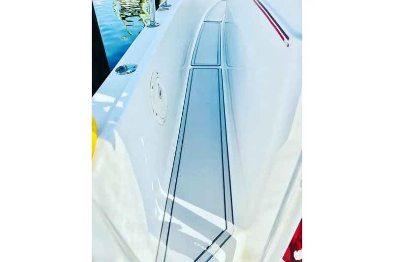 Slide: The Image of 1996 Pro-Line 2950 Walkaround boat deck with sleek white finish and water reflection. - 11