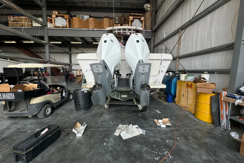 Slide: The Image of 1996 Pro-Line 2950 Walkaround boat in a workshop with dual outboard motors. - 17