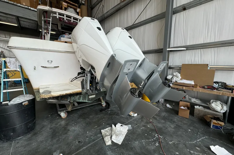 Slide: The Image of 1996 Pro-Line 2950 Walkaround boat with dual outboard motors in a workshop setting. - 18