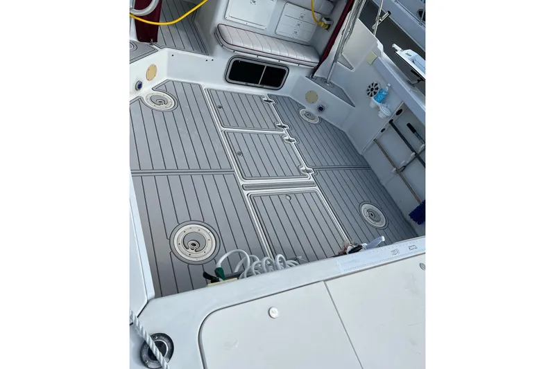 Slide: The Image of 1996 Pro-Line 2950 Walkaround boat deck with gray flooring and storage compartments. - 6