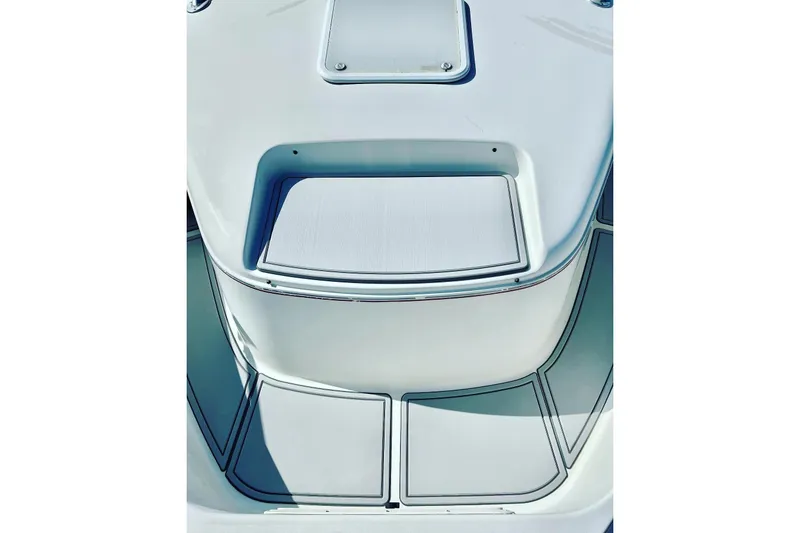 Slide: The Image of 1996 Pro-Line 2950 Walkaround boat deck, featuring sleek white design and storage compartments. - 7