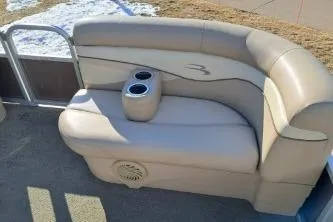 Slide: The Image of 2014 BENNIGTON S21 boat seating with cup holders, beige upholstery, outdoor setting. - 10