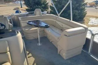 Slide: The Image of 2014 BENNIGTON S21 pontoon boat interior with beige seating and a small table. - 13