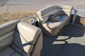 Slide: The Image of 2014 Bennington S21 boat interior with beige seating and cup holders. - 16