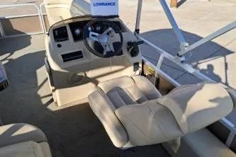 Slide: The Image of 2014 Bennington S21 boat interior with steering wheel and beige seating. - 17
