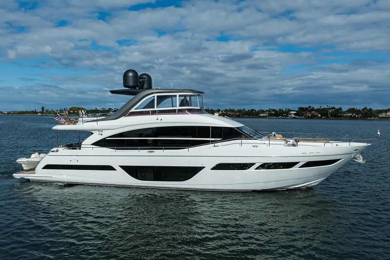 The Image of Luxurious 2021 Princess Y78 yacht cruising on a serene waterway under a partly cloudy sky. - 0