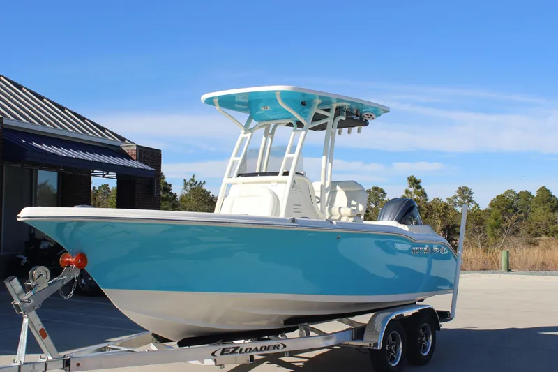 Slide: The Image of 2026 Key West 219 FS boat on trailer, blue hull, parked outdoors. - 2