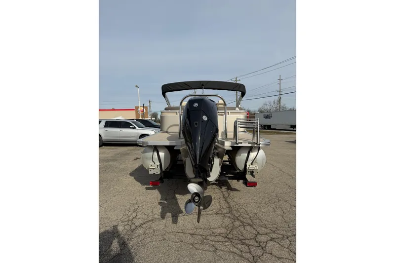 Slide: The Image of 2023 Avalon LSZ QUAD LOUNGE boat with outboard motor in a parking lot. - 1