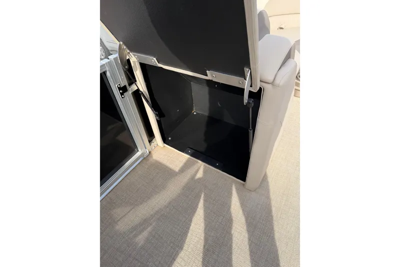 Slide: The Image of 2023 Avalon LSZ QUAD LOUNGE storage compartment with open hatch on beige carpet. - 18