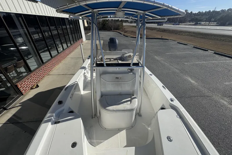 Slide: The Image of 2013 Sea Hunt BX 20 BR boat with T-top, parked near a building. - 12