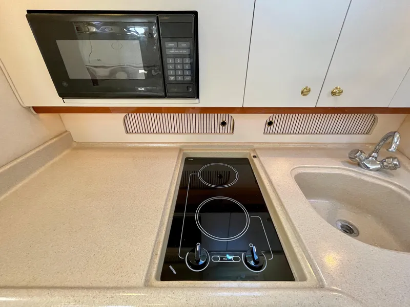 Slide: The Image of 2001 Sea Ray Sundancer 310 kitchen with stove and microwave. - 17