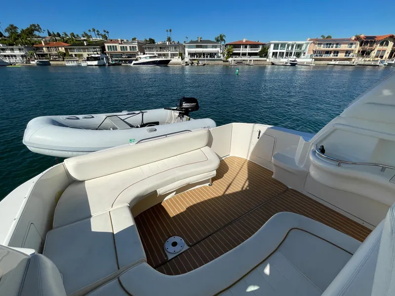 Slide: The Image of 2001 Sea Ray Sundancer 310 with spacious deck and dinghy in water. - 41