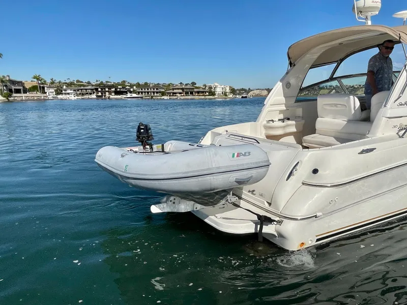 Slide: The Image of 2001 Sea Ray Sundancer 310 with dinghy on calm water. - 6