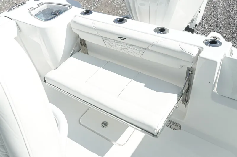 Slide: The Image of 2026 Tidewater 232 CC Adventure boat with white cushioned seating and rod holders. - 17