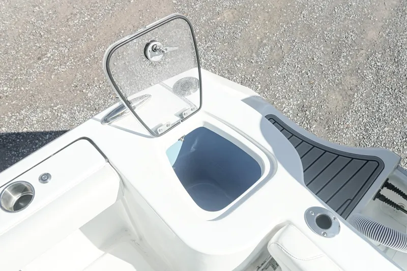 Slide: The Image of 2026 Tidewater 232 CC Adventure boat with open storage compartment and cup holder. - 18