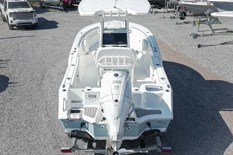 Slide: The Image of 2026 Tidewater 232 CC Adventure boat on trailer, rear view, in a gravel lot. - 4
