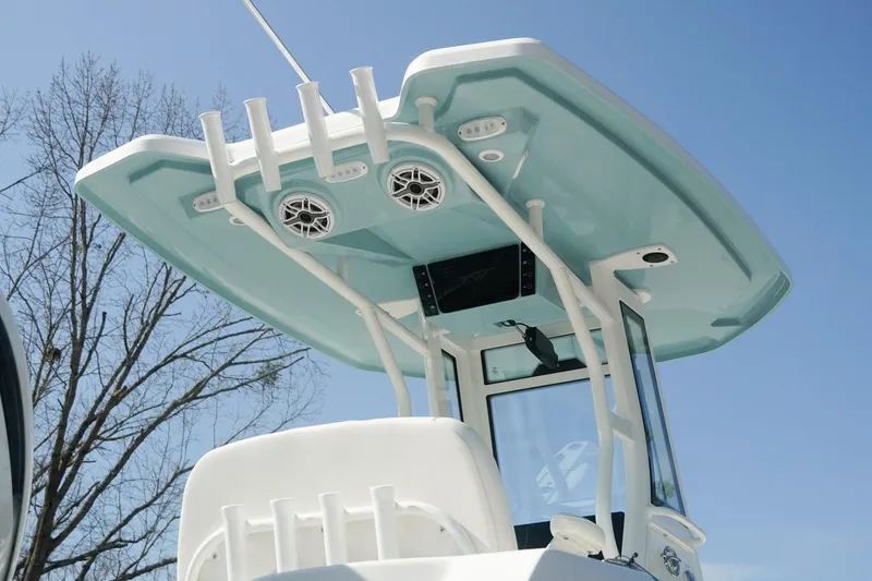 Slide: The Image of 2026 Tidewater 232 CC Adventure boat with T-top and rod holders against blue sky. - 40