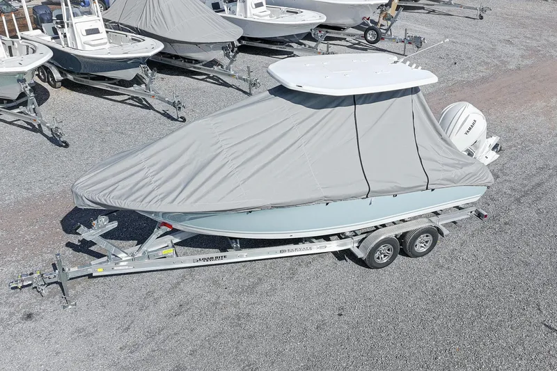 Slide: The Image of Covered 2026 Tidewater 232 CC Adventure boat on trailer in a gravel lot. - 49