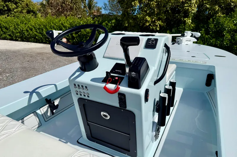 Slide: The Image of 2022 Beavertail Skiffs Vengeance 18 console with steering wheel and controls. - 19