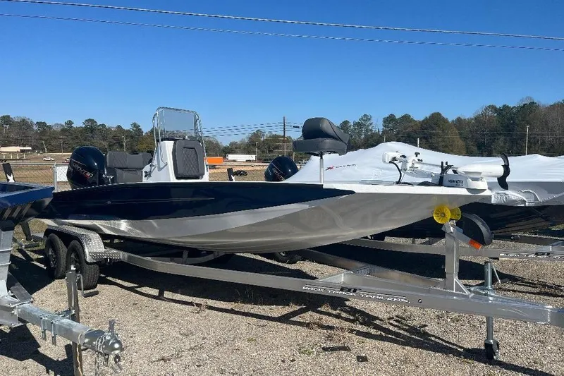 The Image of 2026 Xpress H22B Bay boat on trailer, parked outdoors under clear blue sky. - 0