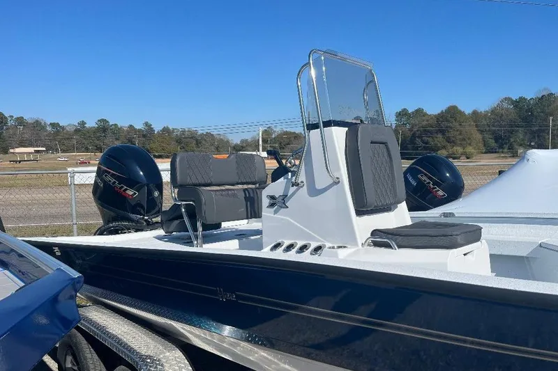 Slide: The Image of 2026 Xpress H22B Bay boat with Yamaha outboard engines, parked outdoors. - 2